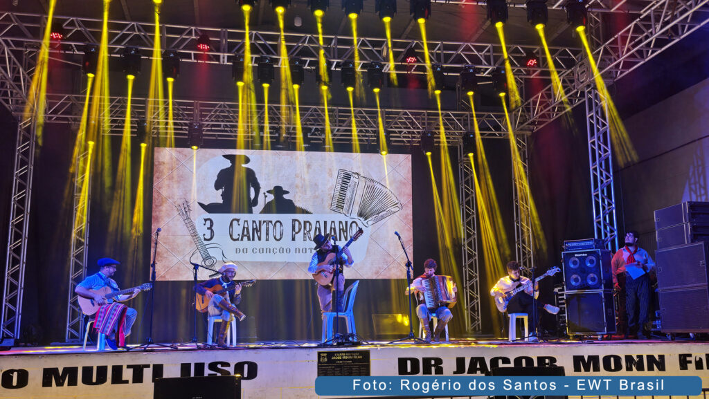 Músicos tocando e cantando defendendo uma de suas canções no III Canto Praiano no CTG Os Praianos